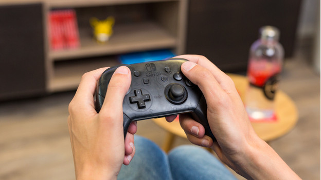 Junge gibt Mädchen Nintendo Switch-Controller.