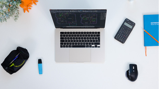 MacBook auf einem Schreibtisch mit Büromaterial