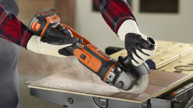 Mann schneidet Fliesen mit BLACK+DECKER Winkelschleifer