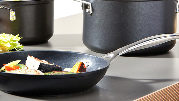 Frying pan with vegetables on kitchen counter