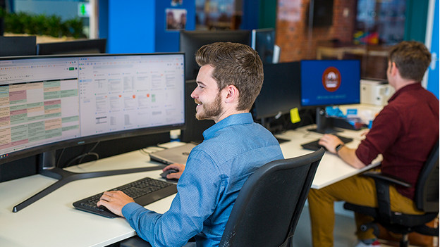 Man works on wide monitor at the office.