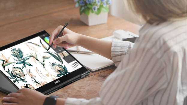 Woman draws with stylus on 2-in-1 laptop