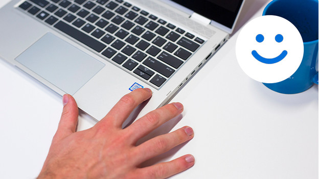 Männliche Hand meldet sich über den Fingerabdrucksensor des Laptops an. Windows Hello-Logo in der oberen rechten Ecke.