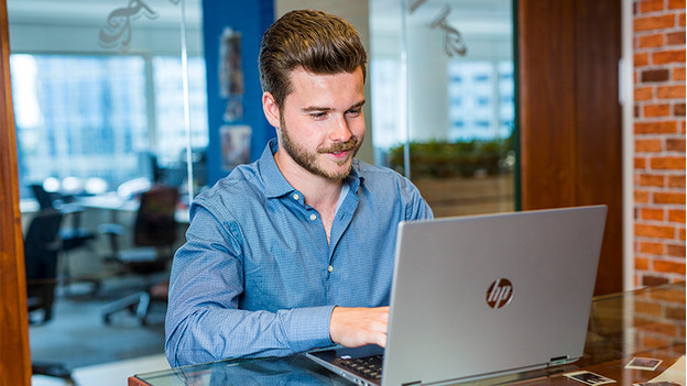 Boy works on HP laptop at the office.