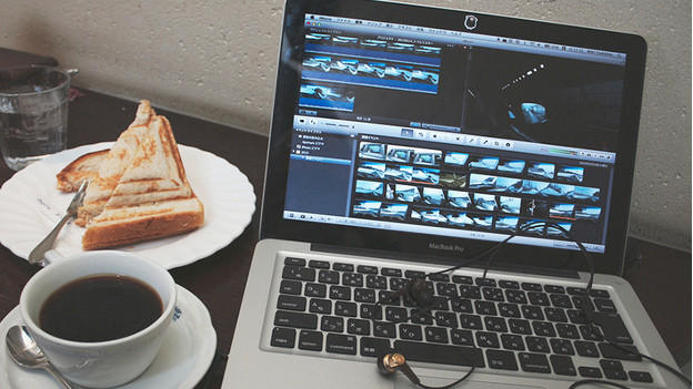 Editing videos on a MacBook Pro with a grilled cheese and a cup of coffee.