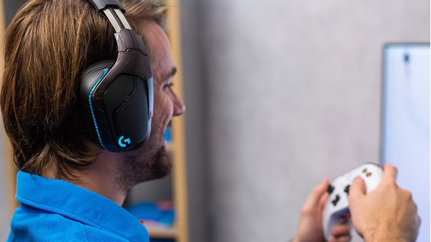 Mann mit einem Xbox-Controller in der Hand und einem Gaming-Headset auf dem Kopf