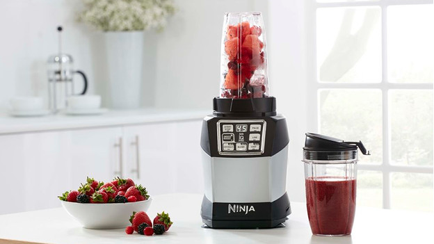 Ninja-Mixer und mit roten Früchten gefüllter Mixbecher