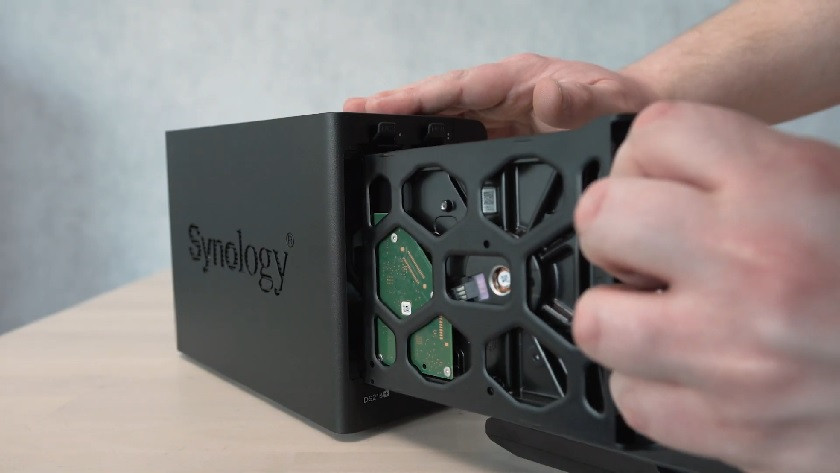 Expert places an internal hard drive into a Synology NAS