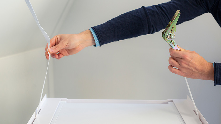 Ziehe den Gurt von unten nach oben durch.