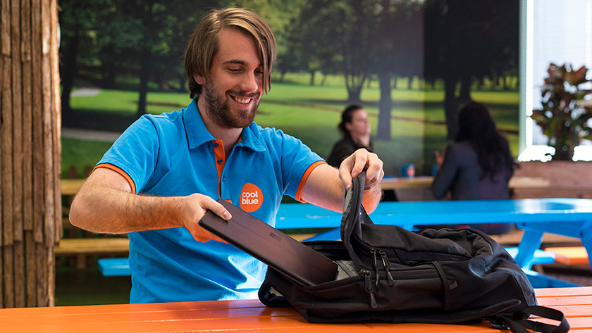 Man putting laptop in his backpack.