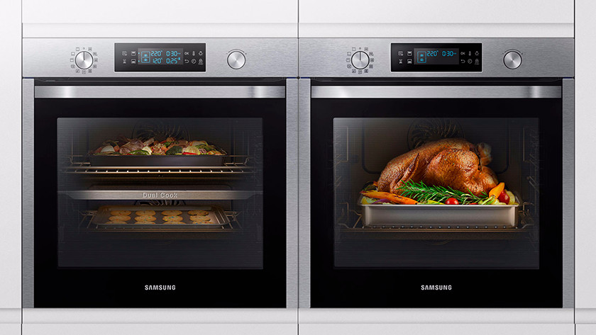 2 ovens with potatoes, chicken, and vegetables