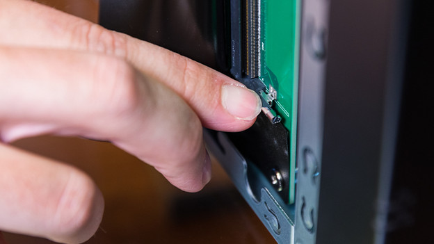 Man presses down the pin of the RAM slot