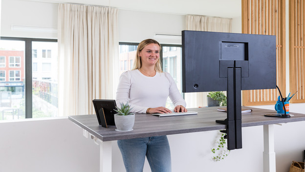 Frau vor Bildschirm mit Monitorhalterungen