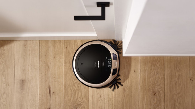 Miele robot vacuum with side brushes in corner