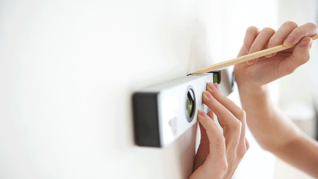 Drawing on the wall with spirit level and pencil.