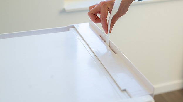 Stecke den Gurt von oben nach unten durch den mittleren Schlitz.