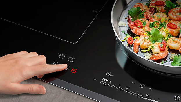 A cooktop with a hand