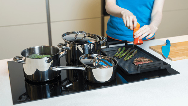 Töpfe mit Deckel auf einem Kochfeld