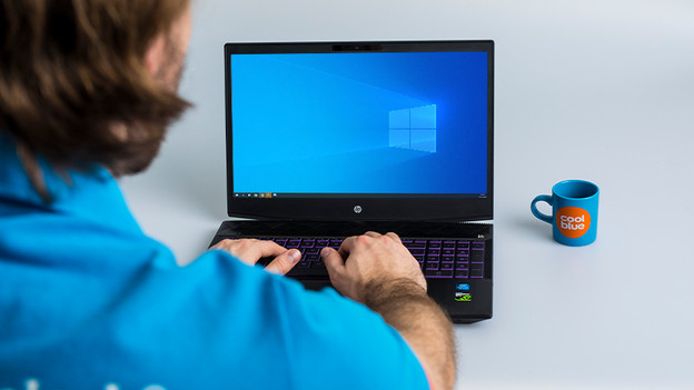 Man works on an HP Windows laptop.