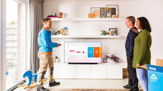 Coolblue delivery driver in living room with television and customers