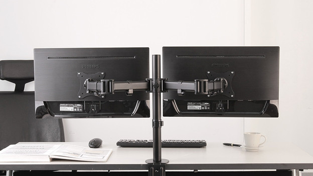 An Monitorhalterungen angebrachte Monitore für eine ergonomische Sitzposition.