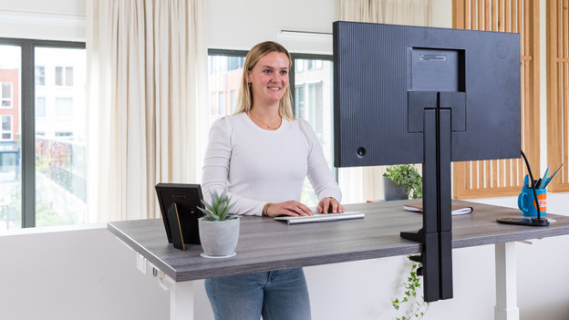 Person in front of a screen with monitor arms