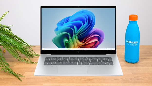 Frau arbeitet an einem 17-Zoll-Laptop mit verschiedenem Zubehör auf dem Schreibtisch.