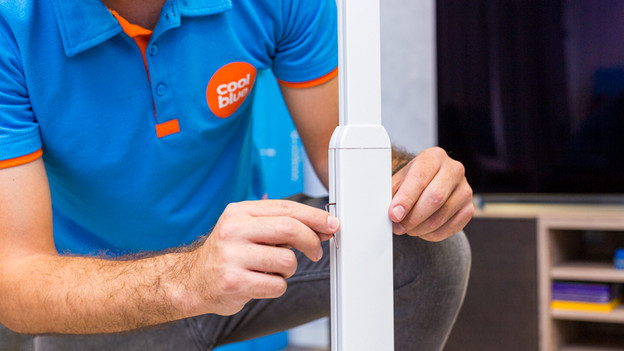 Someone adjusts the pole of the BlueBuilt speaker stand