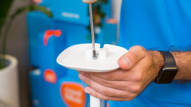 Someone attaches the speaker mount to the BlueBuilt speaker stand