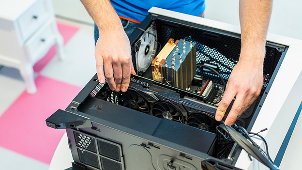 Experte legt Grafikkarte in das Gehäuse ein